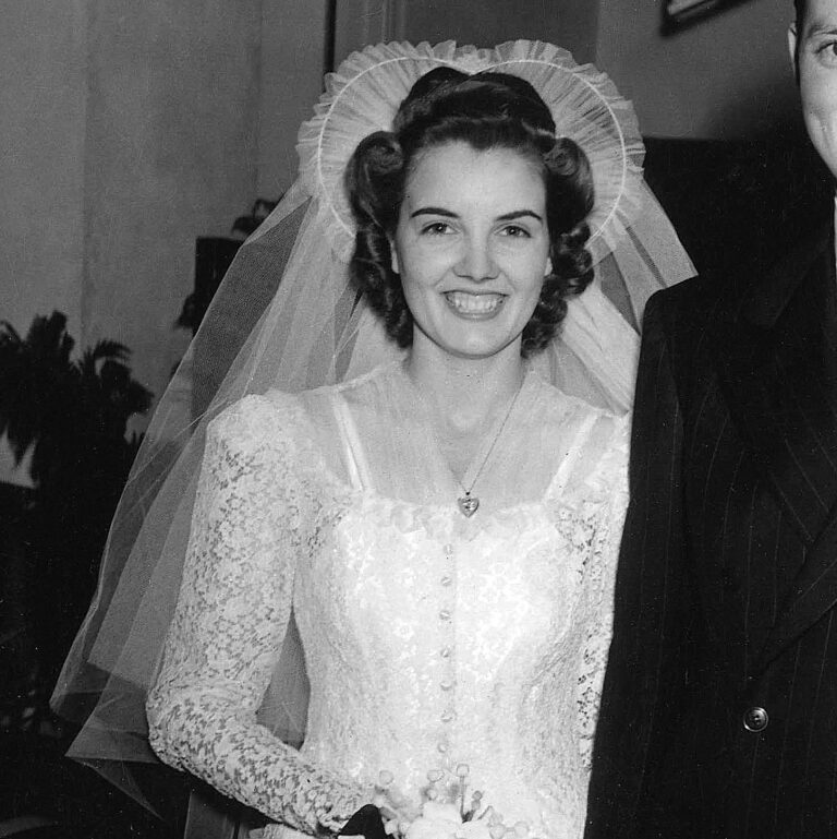 1940s bride with victory roll hairstyle wearing sweetheart wedding veil and lace wedding dress