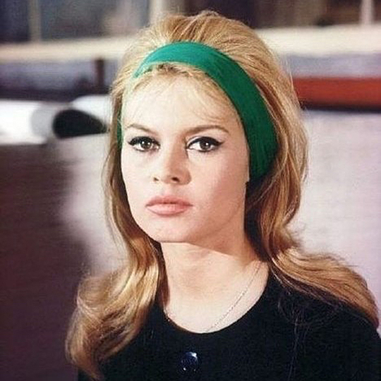 brigitte bardot with her hair down wearing a green headband in the early 1960s
