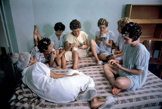 college women playing cards wearing hair rollers in pajamas 1960s