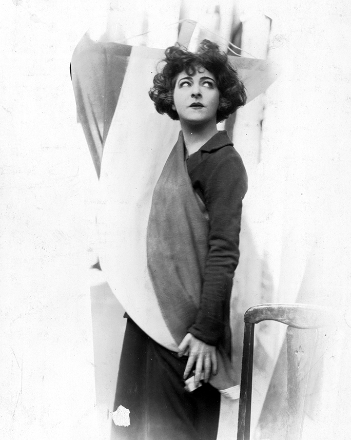 Actress Madame Alla Nazimova standing with a suffragist flag